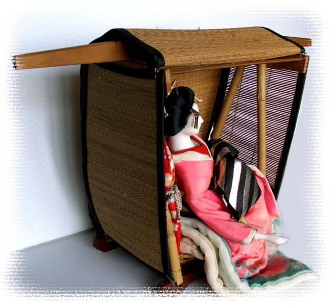japanese traditional geisha doll siting in straw carriage, antique