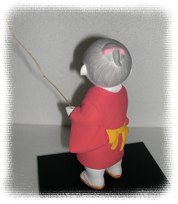 Japanese Hakata ceramic doll of a Boy with twig