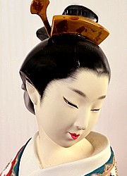japanese hakata doll of a lady dressed with red  kimono with cherry blossom motif